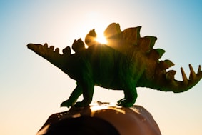 green and brown dinosaur figurine