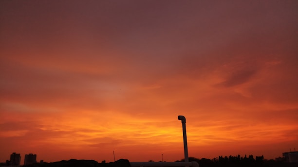 A vibrant sunset over the ancient forts of Rajasthan, with warm orange and pink hues lighting up the sky.