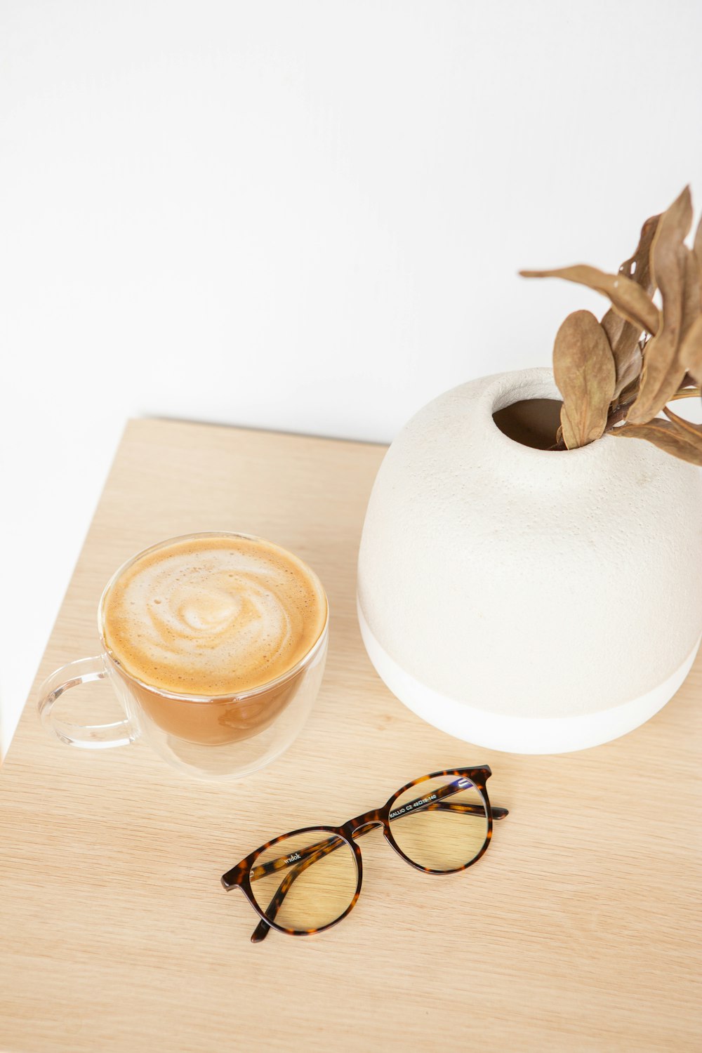 white round ceramic plate beside black framed eyeglasses