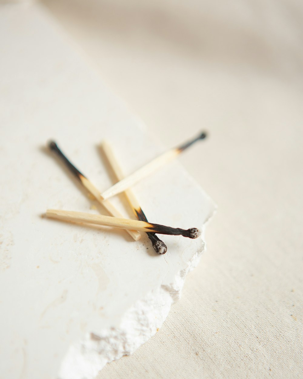 braune und weiße Holzstäbchen auf weißer Oberfläche