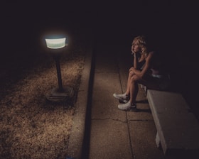 woman in black tank top sitting on concrete floor