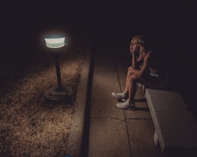 woman in black tank top sitting on concrete floor