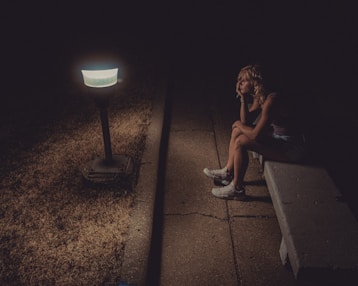 woman in black tank top sitting on concrete floor