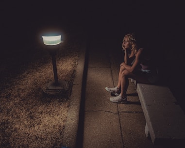 woman in black tank top sitting on concrete floor