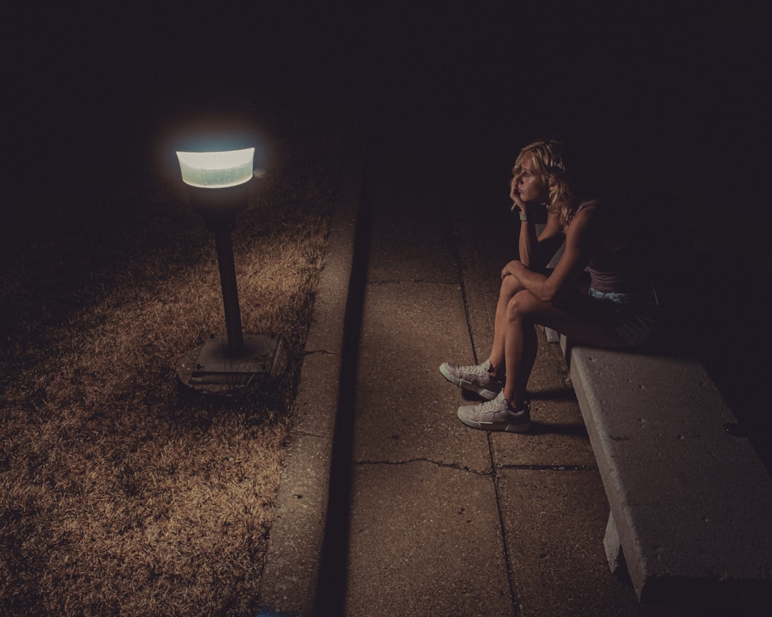 woman in black tank top sitting on concrete floor,
