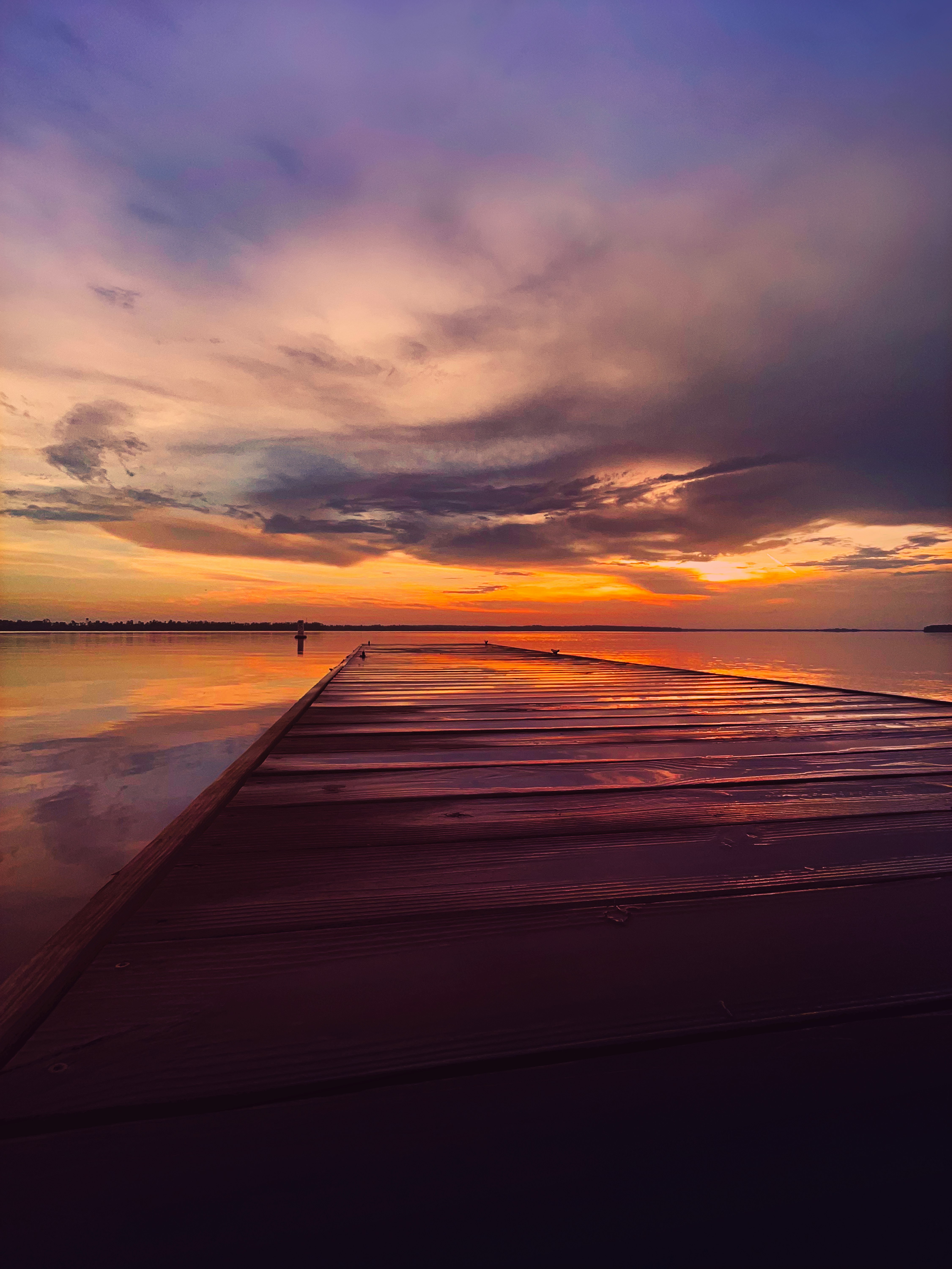 brown wooden dock on sea during sunset