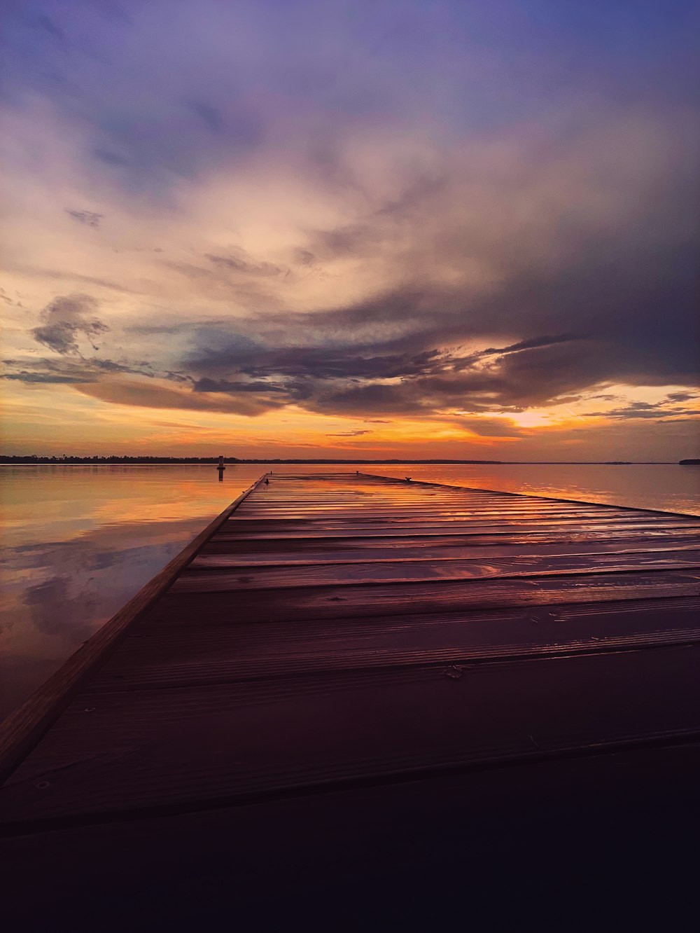 muelle de madera marrón en el mar durante la puesta del sol