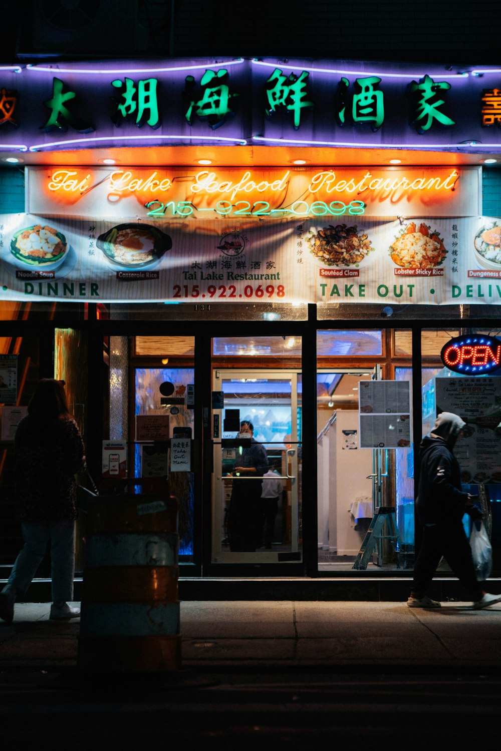 man in black jacket standing near store during nighttime