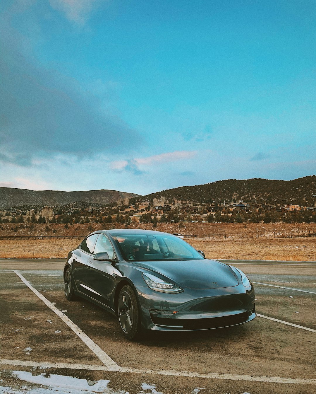 black sedan on gray asphalt road during daytime