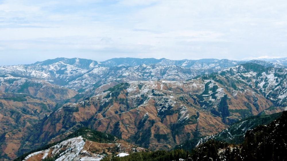 brown and green mountains under white sky during daytime