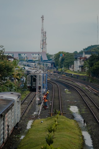 A group of trainees in high-visibility gear learning track maintenance on a sunny Australian rail site.