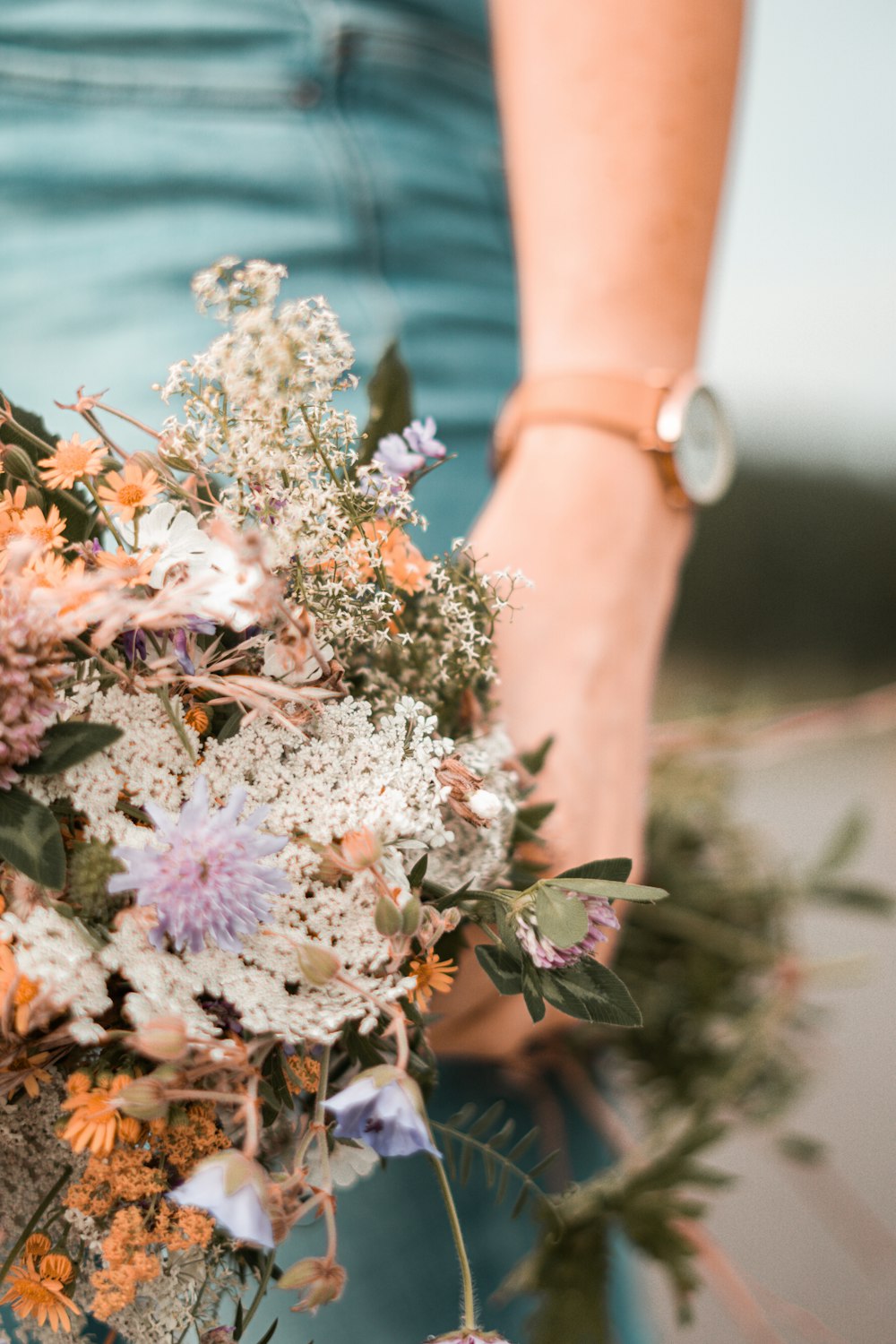 person holding pink and white flowers