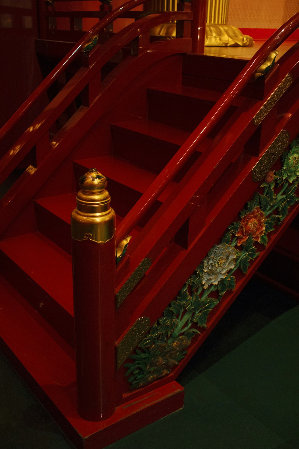 red wooden staircase with gold and red floral print