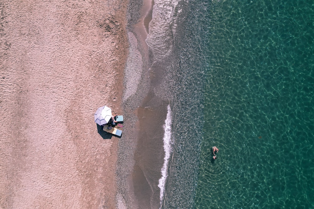 Vue aérienne d’un bateau blanc sur le rivage de la mer pendant la journée
