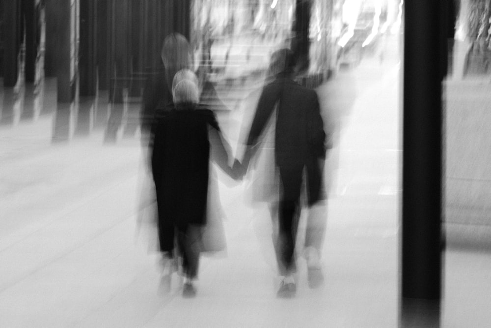 man and woman walking on snow covered ground