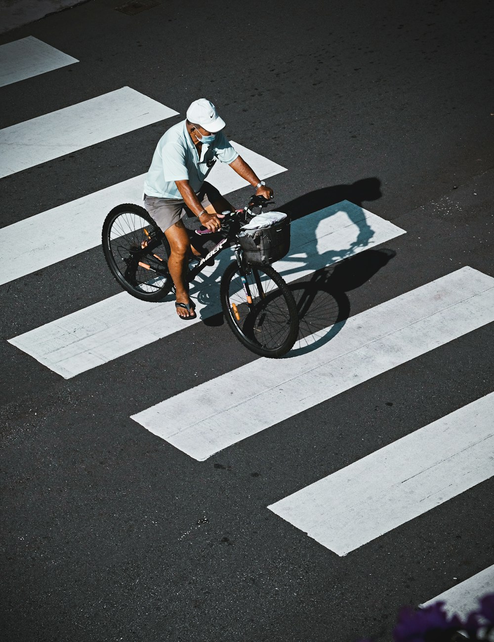 man in white shirt riding on black bicycle