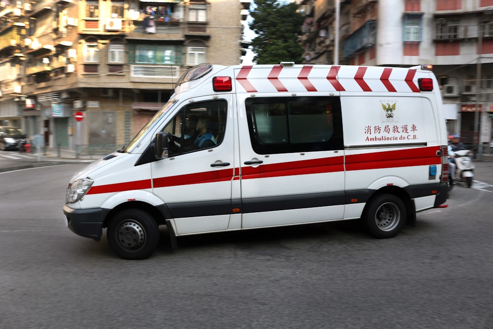 white and red ambulance parked on street during daytime
