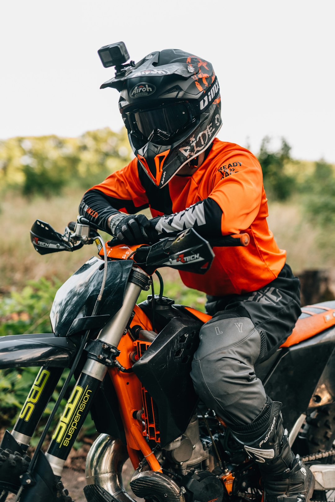 man in orange jacket riding black motorcycle