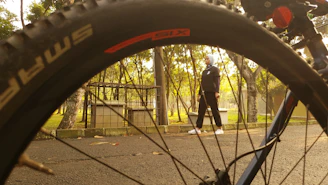A confident woman cycling along a coastal road at sunset, wearing lightweight, modest gear with a wind-blown hijab.