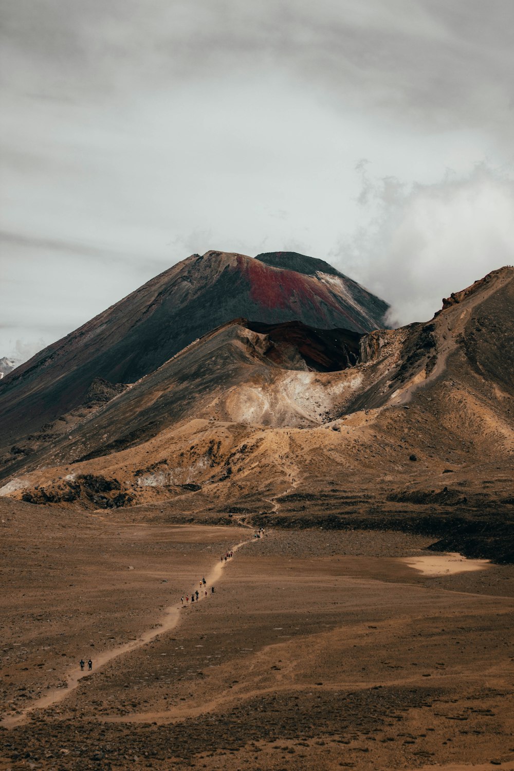 brown and black mountain under white clouds