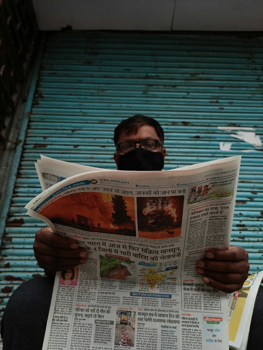 man in black long sleeve shirt reading newspaper
