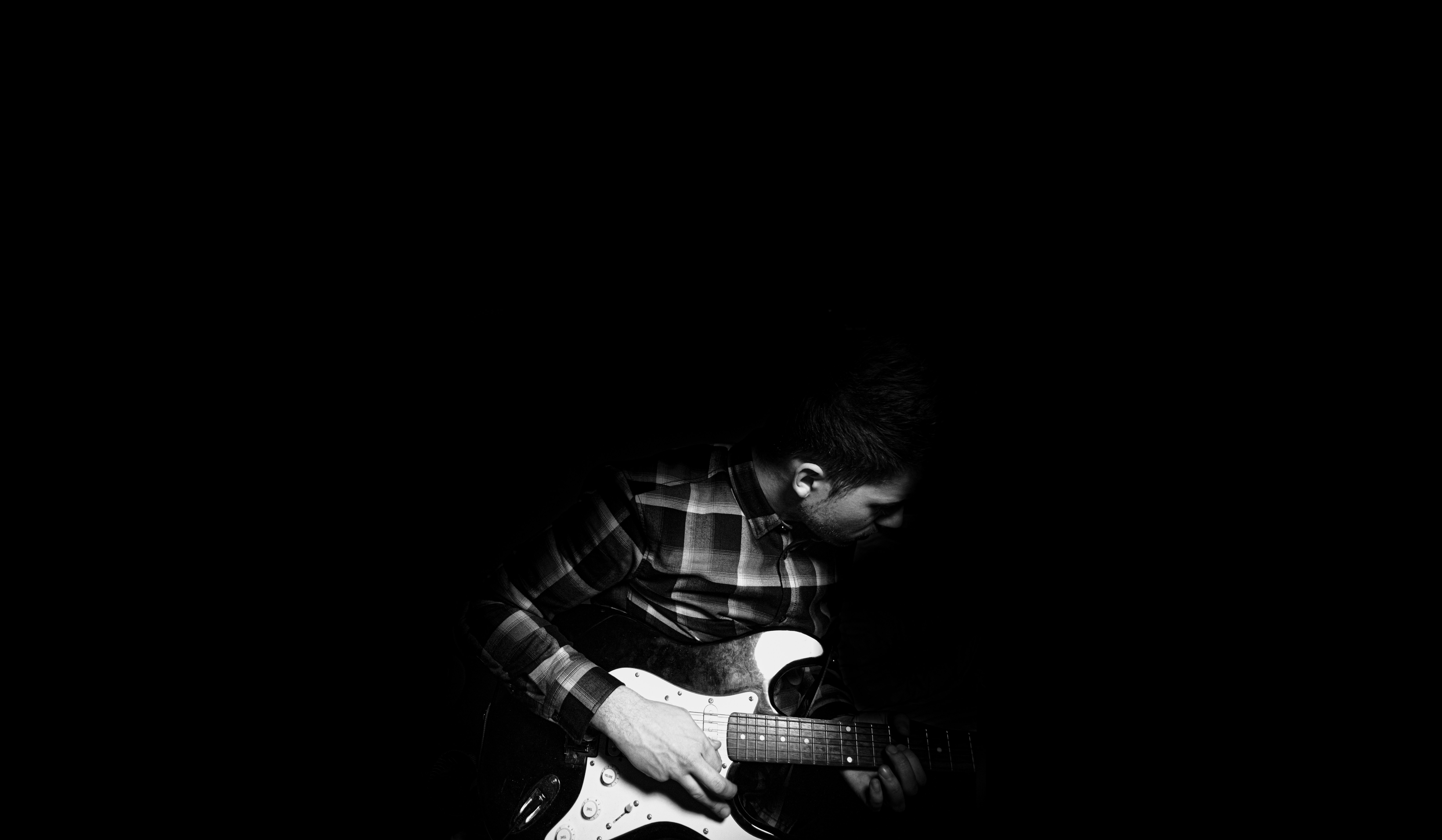 Mann spielt Gitarre in Graustufenfotografie