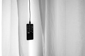 black remote control on white textile