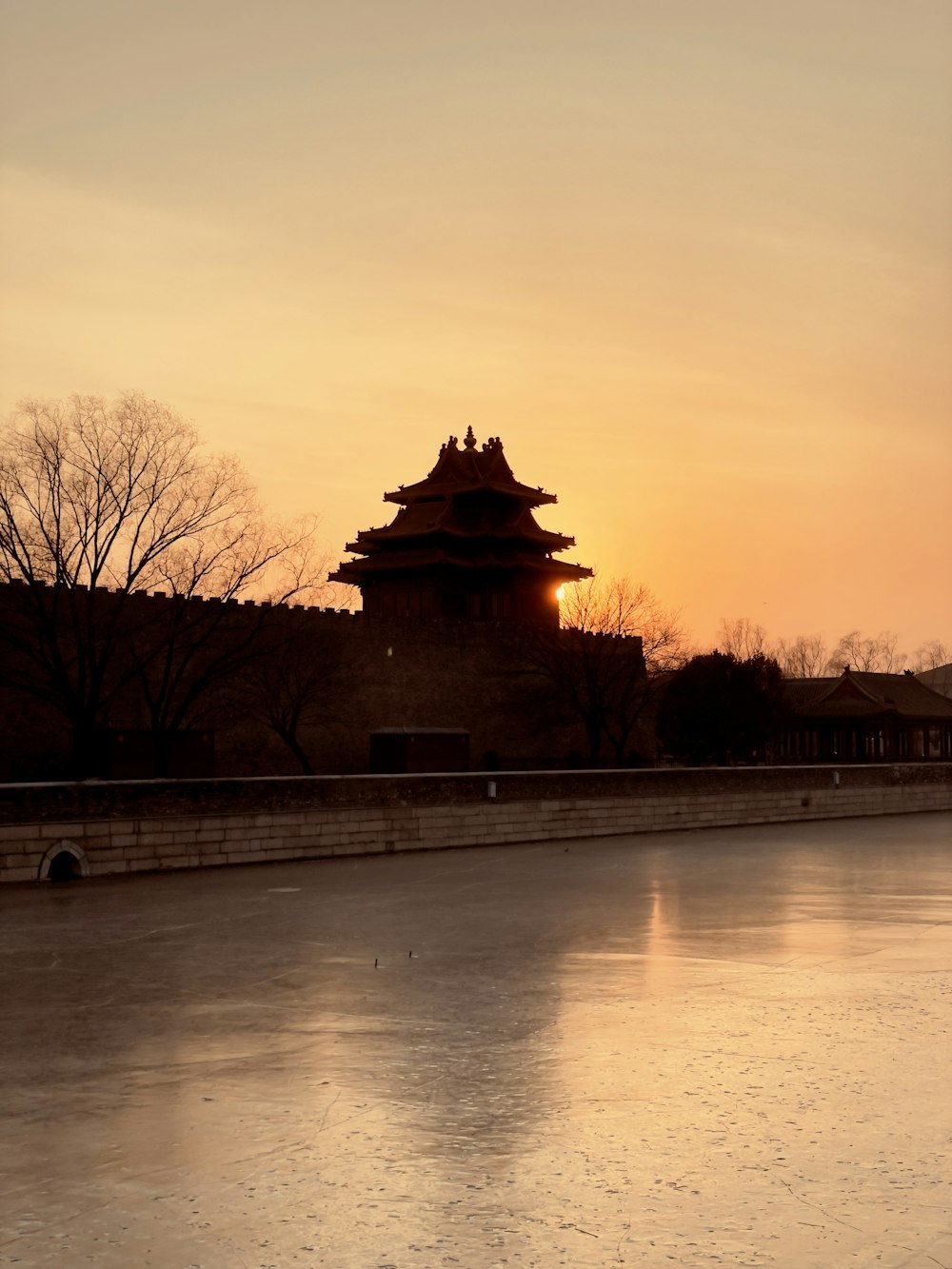 silhouette of temple near body of water during sunset