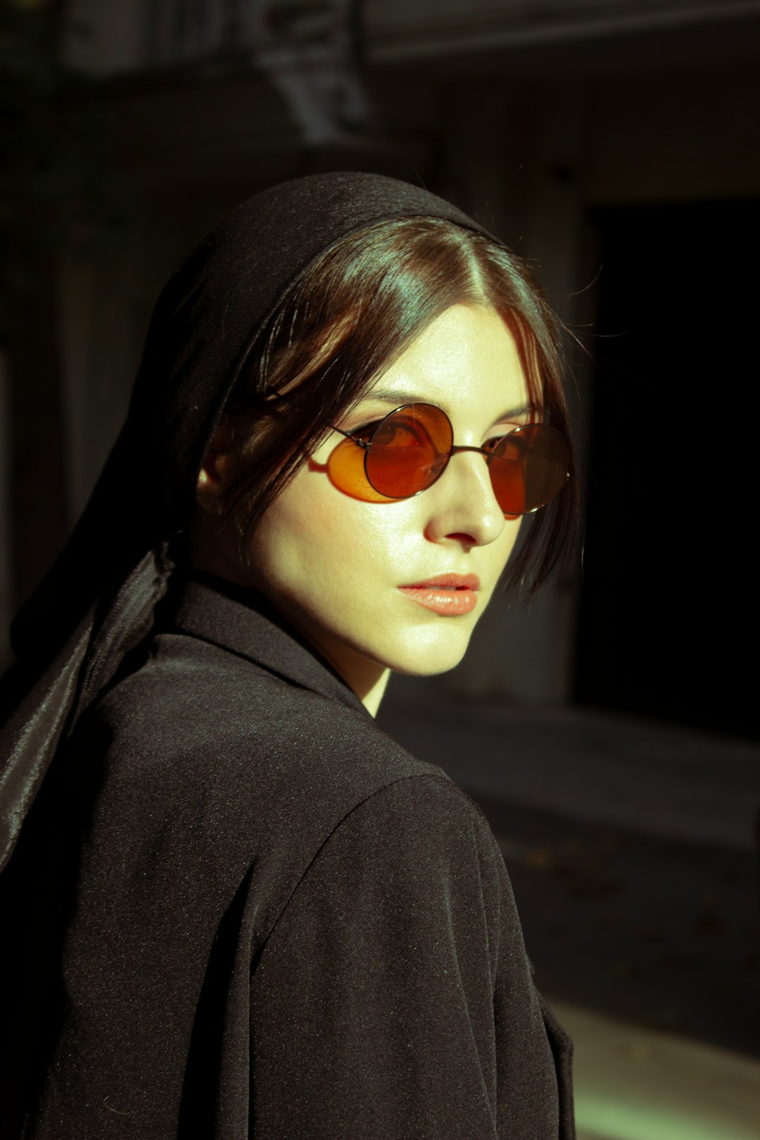 woman in black coat wearing brown sunglasses