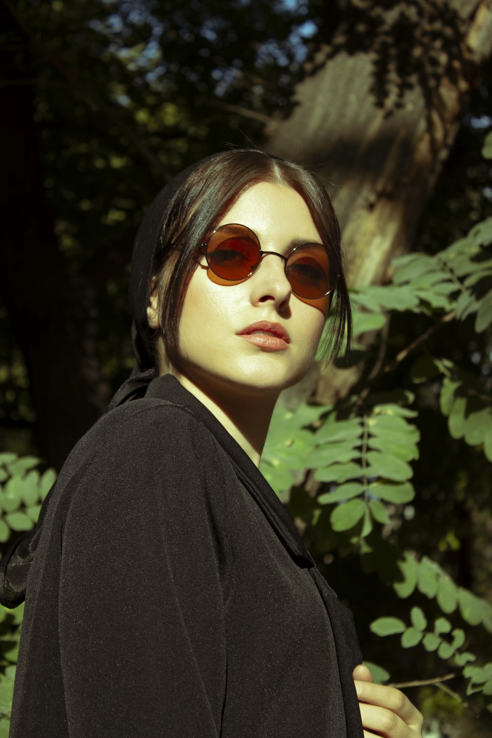 woman in black coat and brown sunglasses