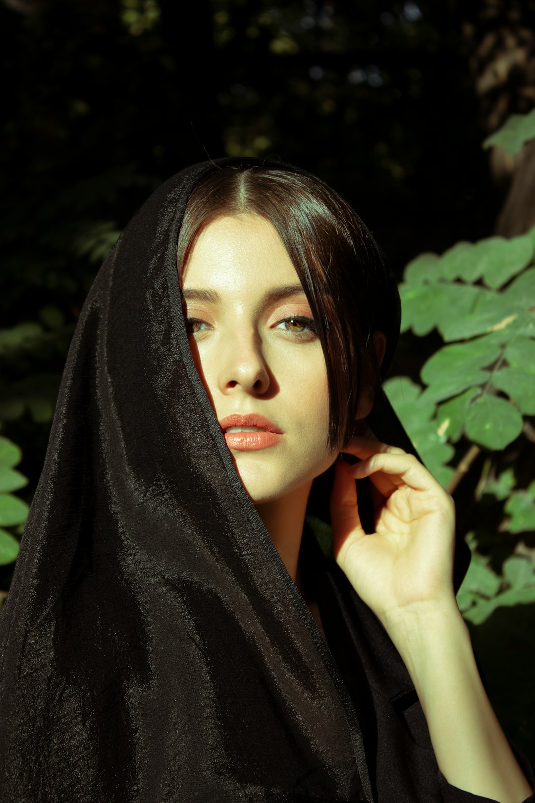 woman in black hijab near green leaves