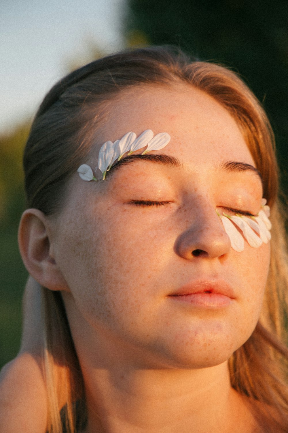 woman with blue and white flower on her face