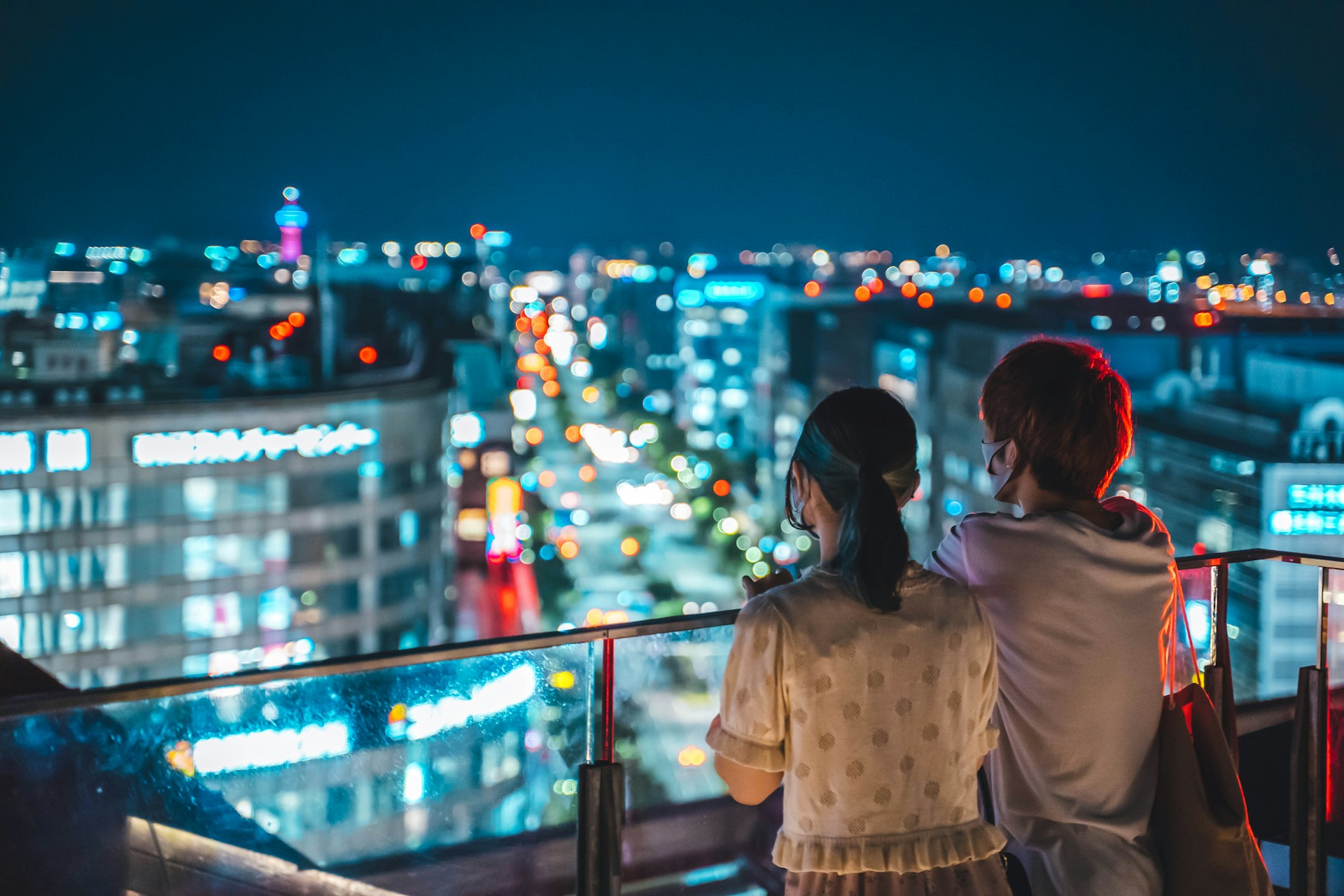 woman in white shirt standing near railings during night time