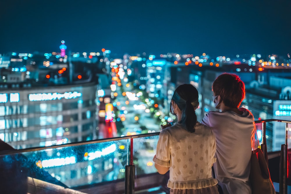 woman in white shirt standing near railings during night time