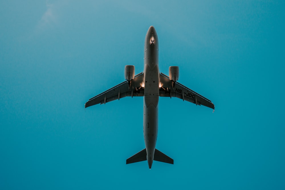 gray airplane in mid air during daytime