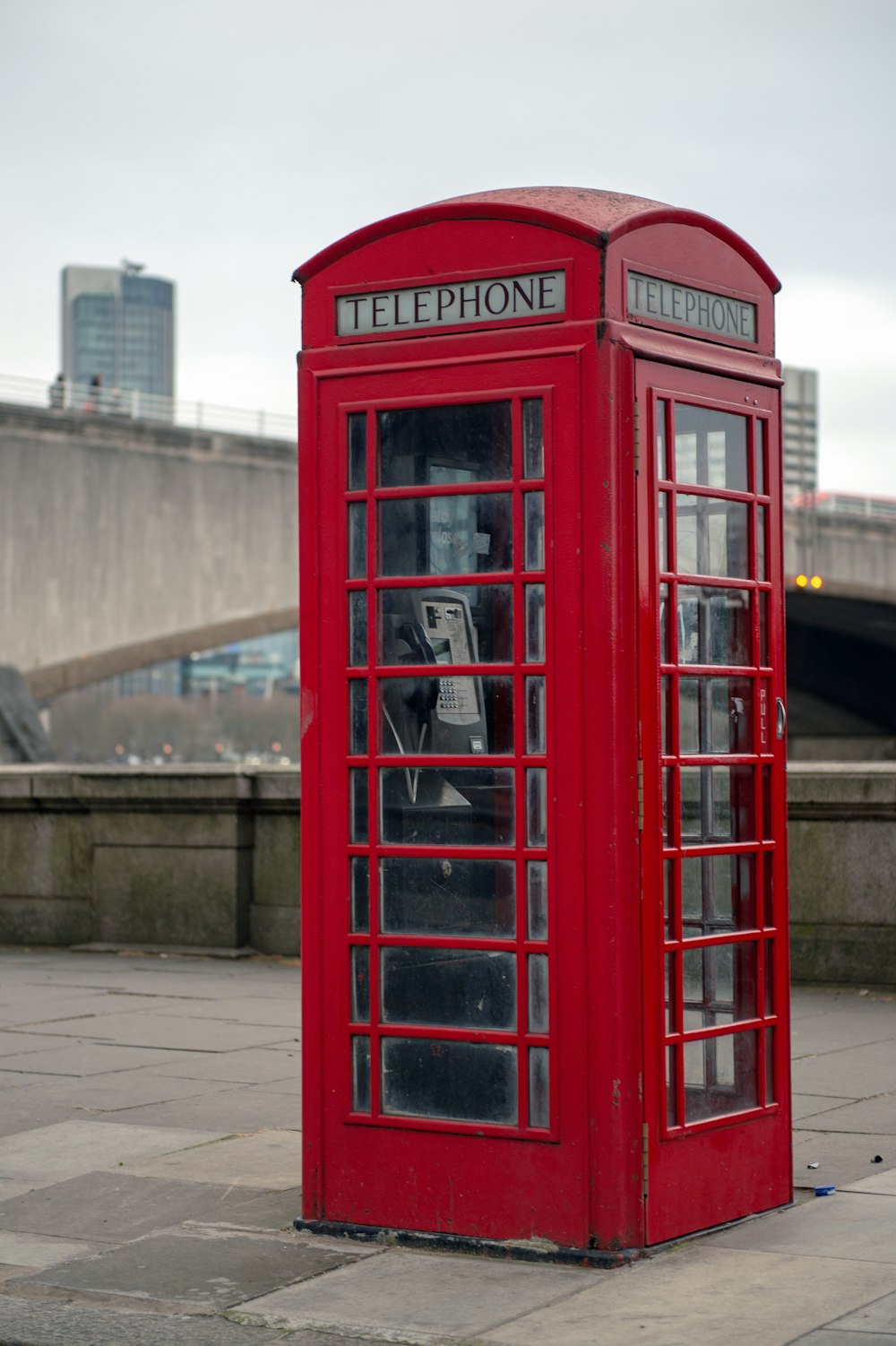 Cabine téléphonique rouge près de l’immeuble Brown pendant la journée