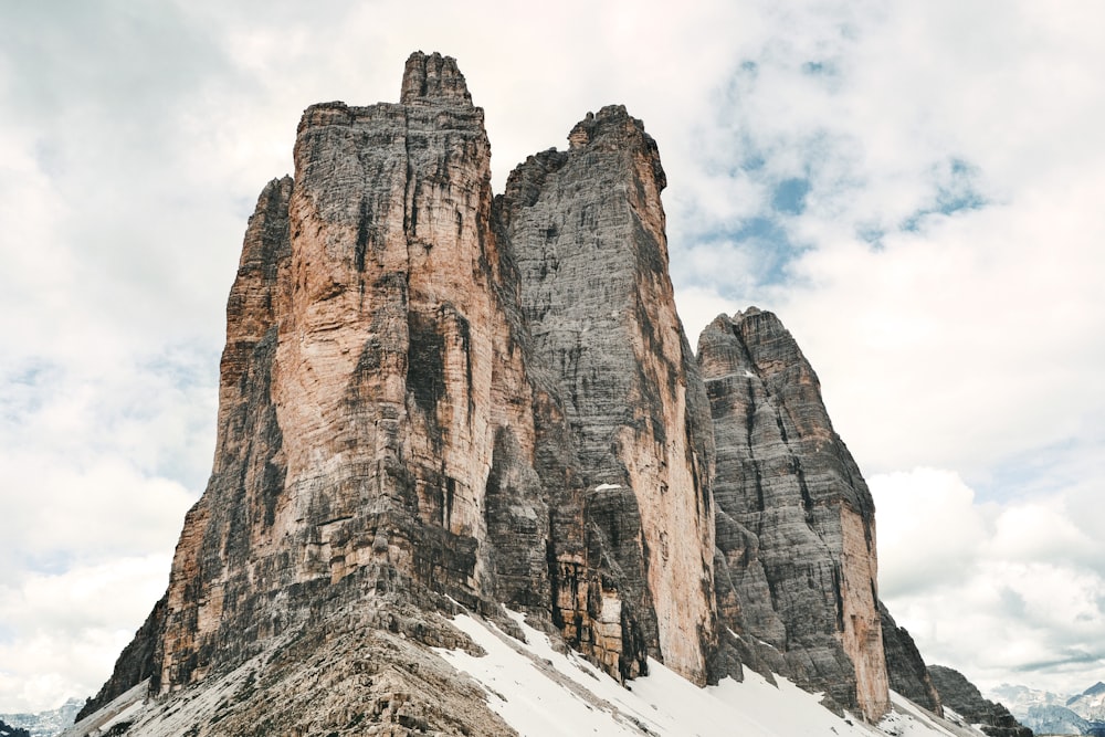 brown rocky mountain under white clouds during daytime