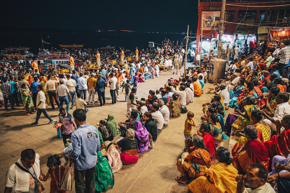 people sitting on brown wooden bench during nighttime