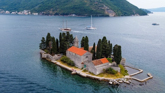 brown and white concrete house beside body of water during daytime in Perast Montenegro