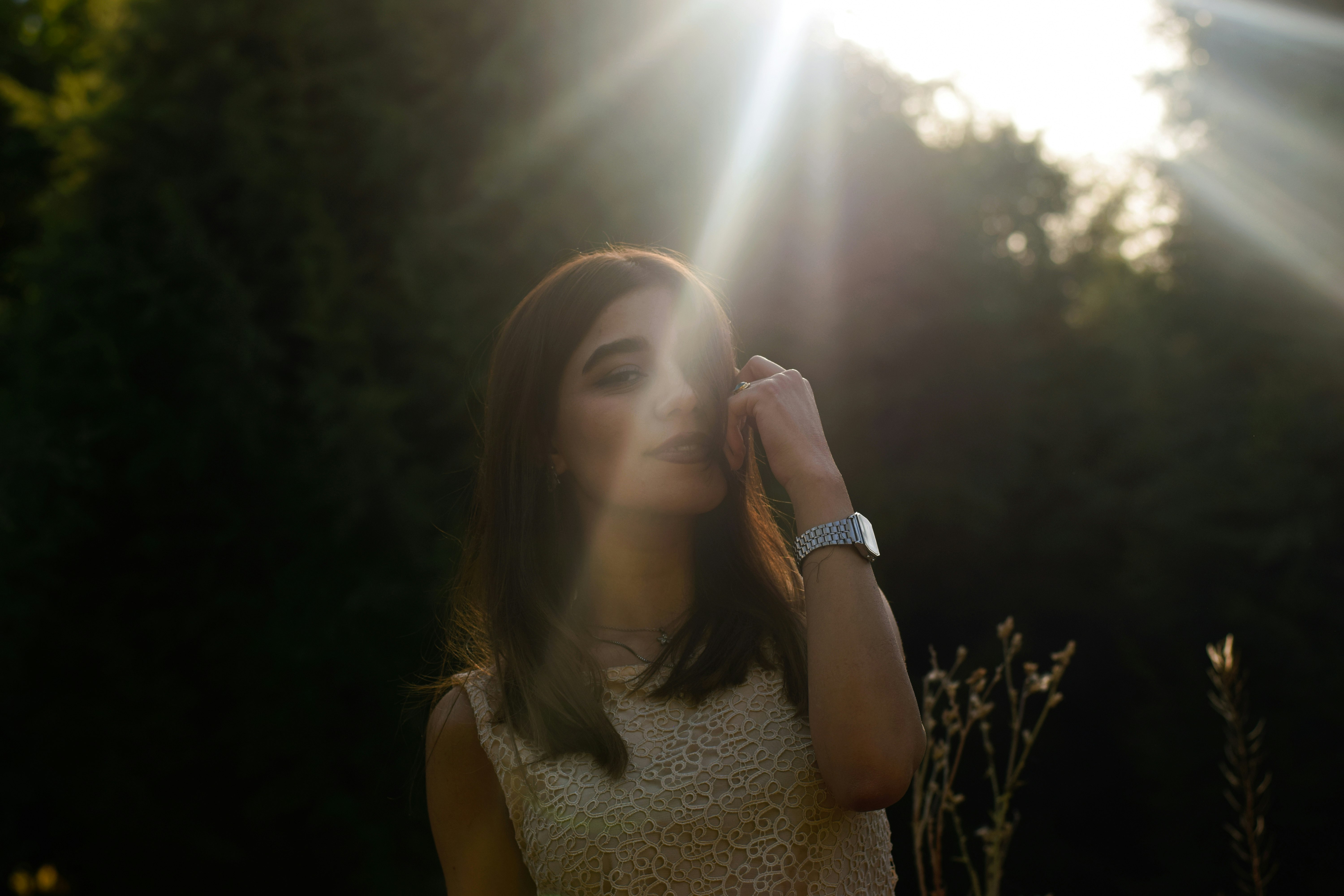 woman in white tank top holding her face