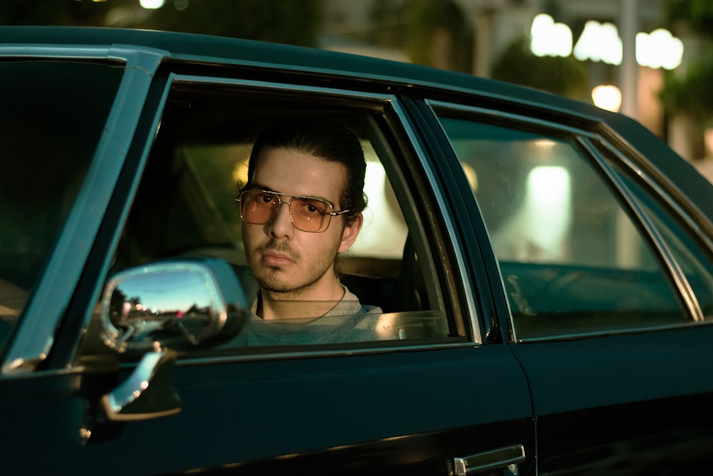 man in black framed eyeglasses driving car during daytime