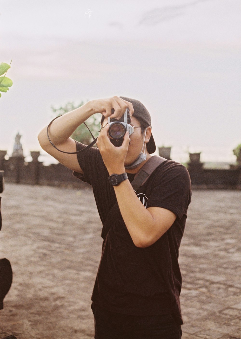 man in black crew neck t-shirt holding black dslr camera