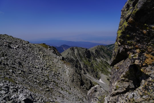 green and gray rocky mountain under blue sky during daytime in Rila National Park Bulgaria