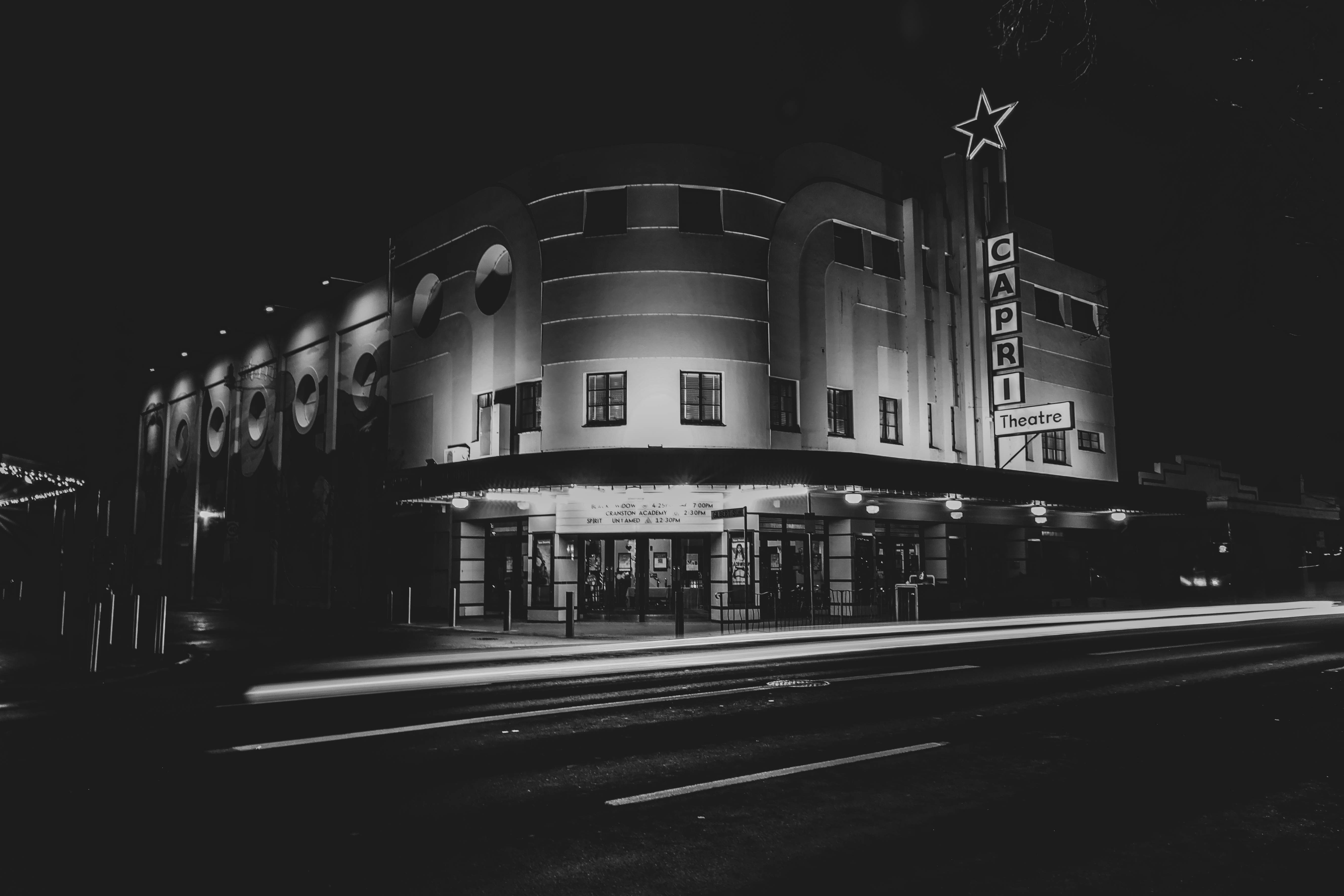 grayscale photo of building with lights turned on during night time
