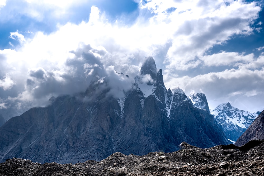 Montaña cubierta de nieve bajo nubes blancas durante el día