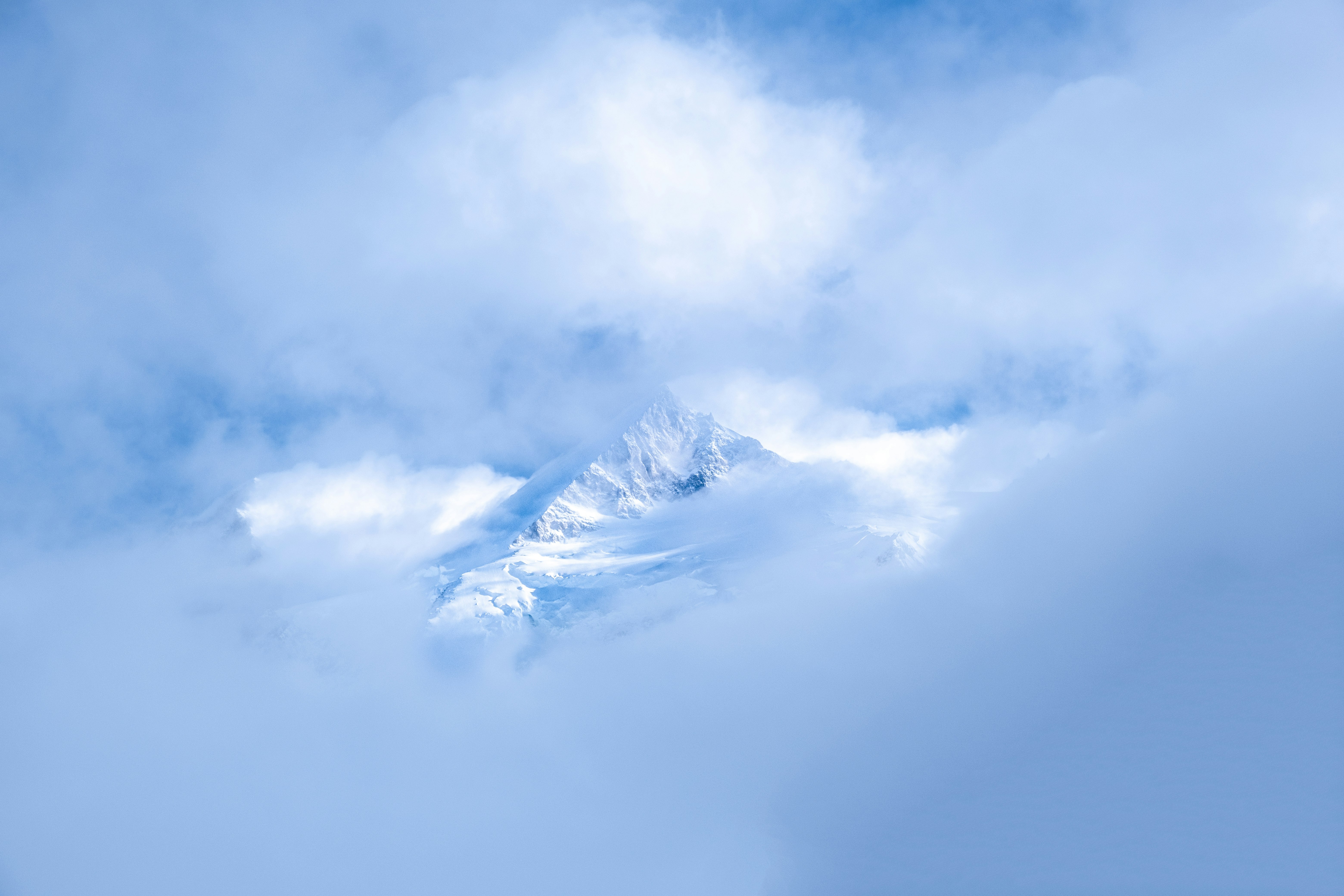 white clouds over snow covered mountains