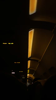 A cozy economy class cabin with comfortable seats and warm lighting, showing passengers enjoying their flight.