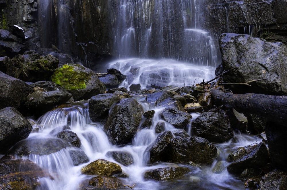 water falls on rocky shore during daytime