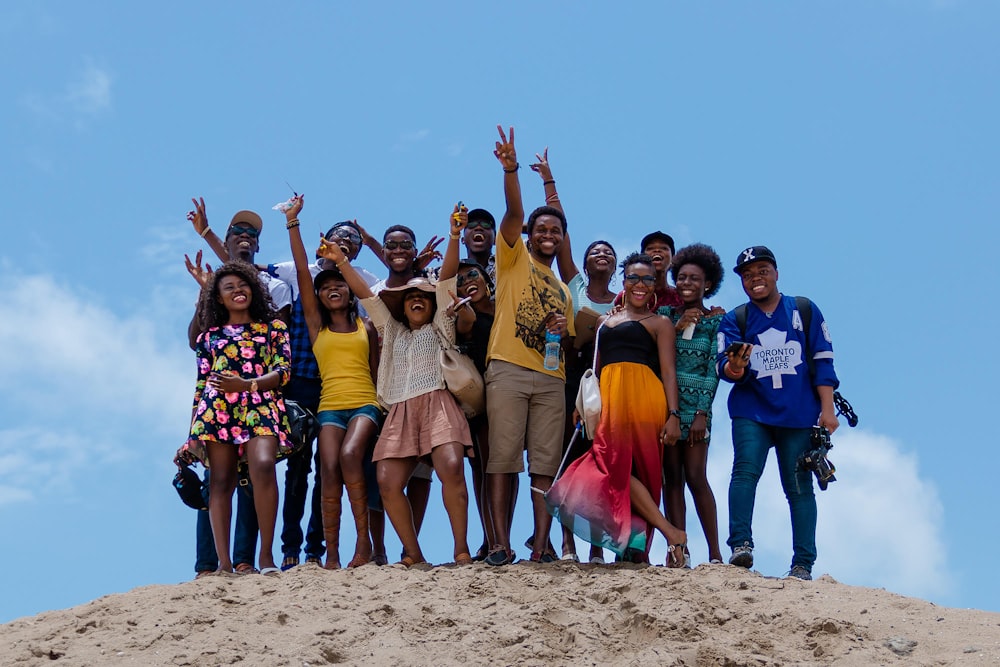 groupe de personnes debout sur le sable brun pendant la journée