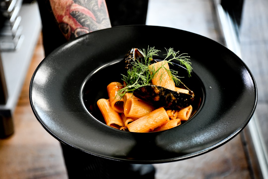 sliced carrots and green vegetable on black ceramic bowl